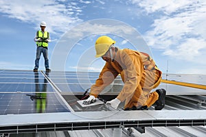 Technician Installing Equipment and Wiring Connect in System of Photovoltaic Installation on Factory Roof Buildings with Engineer