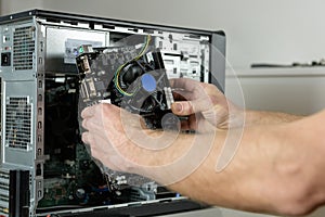 A technician is installing the motherboard in the desktop