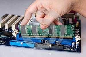 Technician installing RAM stick (random access memory) to socket