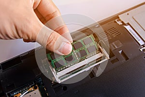 Technician installing RAM stick (random access memory) to socket