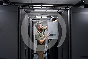 IT technician installing server hardware in a data center server rack maintenance environment