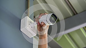 Technician installing wireless CCTV camera by screwed for home security system and installed w