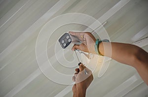 Technician installing wireless CCTV camera by screwed for home security system and installed w