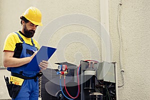 Technician looking for refrigerant leaks photo