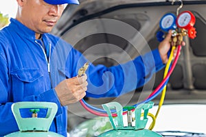 Technician man check car air conditioning system refrigerant recharge, Repairman holding monitor tool to check and fixed car air