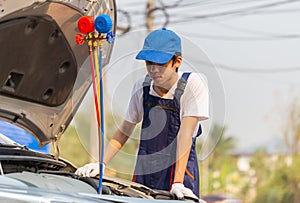 Technician man check car air conditioning system refrigerant recharge, Repairman with monitor tool to check and fixed car air