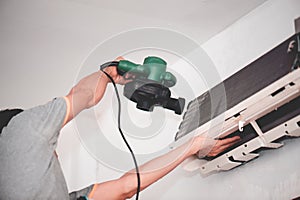 Technician man dry up and dust cleaning air Conditioner filter with electric blowers