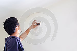 Technician man installing air conditioning in a client house, Electrician mounting the wires into wall, Repairman fixing air