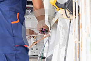 Technician man installing air conditioning in a client house, Young repairman fixing air conditioner unit, Maintenance and