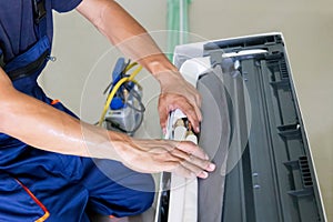 Technician man installing an air conditioning in a client house, Young repairman fixing air conditioner unit, Maintenance and