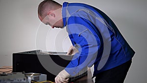 technician man remove motherboard from desktop computer and examine it