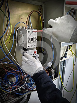 Technician manipulating electrical panel with screwdriver