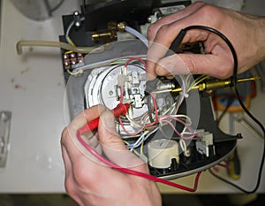 Technician measures resistance of the sensor of coffeemachine.