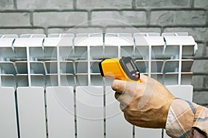Technician measures the temperature of the heater radiator.