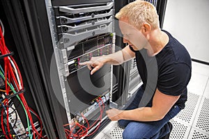 IT Technician Monitors Server On Rack In Datacenter photo