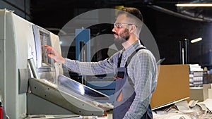 Technician operator checking input and output status on touchscreen front display monitor station at print plant factory