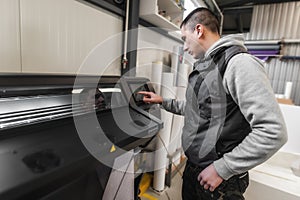 Technician operator checking status on touchscreen front display monitor station