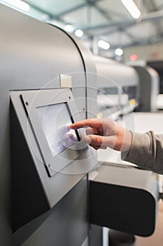 Technician operator checking status on touchscreen front display monitor station