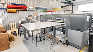 Technician operator works on large premium industrial printer plotter machine