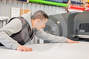 Technician operator works on large premium industrial printer plotter machine