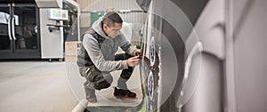 Technician operator works on large premium industrial printer plotter machine