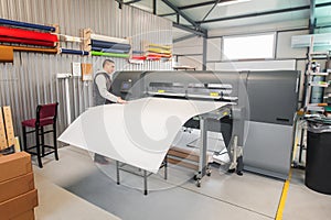 Technician operator works on large premium industrial printer plotter machine