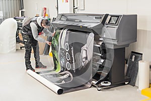 Technician operator works on large premium industrial printer plotter machine