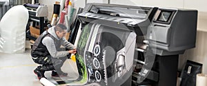 Technician operator works on large premium industrial printer plotter machine