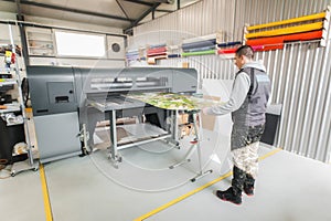 Technician operator works on large premium industrial printer plotter machine