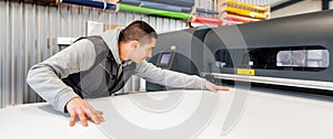 Technician operator works on large premium industrial printer plotter machine