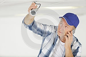 technician on phone fixing cctv camera