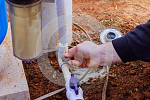 Technician plumber uses clear primer for PVC pipe before a gluing it photo