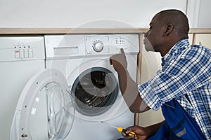 Technician Pressing Button On Washing Machine