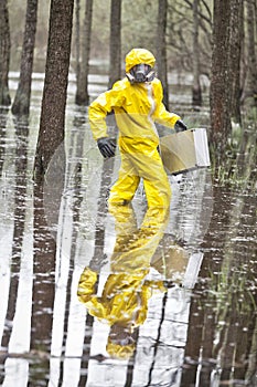 Technician in professional uniform with silver suitcase  in contaminated  floods area photo