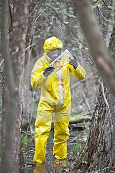 Technician in protective coveralls examining   sample of water