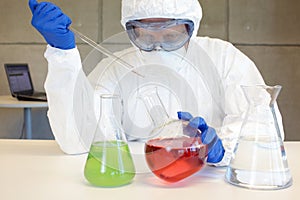 Technician in protective uniform working with chemicals