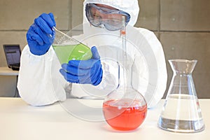 Technician in protective uniform working in lab