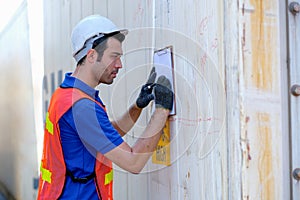 Technician put paper chart on wall of steel container for writing some report of quality check