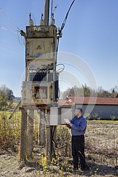 Technician reading the electricity meter to check consumption