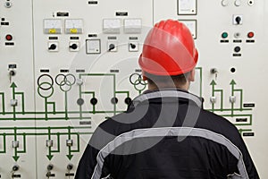 Technician reading instruments in power plant control center