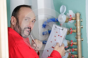 Technician reading water meter to check consumption