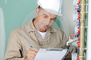 technician reading water meter to check consumption