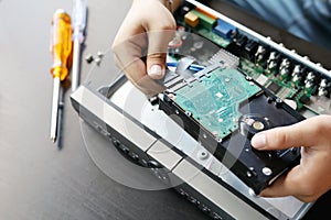 Technician remove a hard disk drive from the CCTV DVR recorder case , to install a new hard drive and upgrading to a Solid State