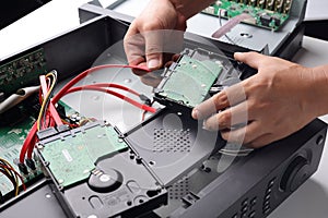 Technician remove a hard disk drive from the CCTV DVR recorder case , to install a new hard drive and upgrading to a Solid State