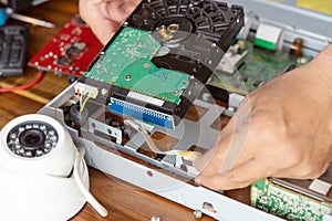 Technician remove a hard disk drive from the CCTV DVR recorder case, to install a new hard drive and upgrading to a Solid State