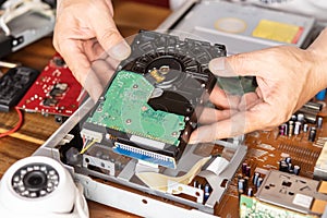 Technician remove a hard disk drive from the CCTV DVR recorder case, to install a new hard drive and upgrading to a Solid State