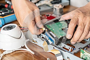 Technician remove a hard disk drive from the CCTV DVR recorder case, to install a new hard drive and upgrading to a Solid State