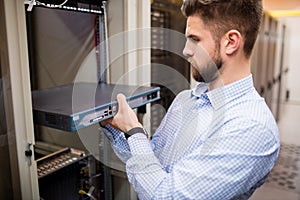 Technician removing server from rack mounted server