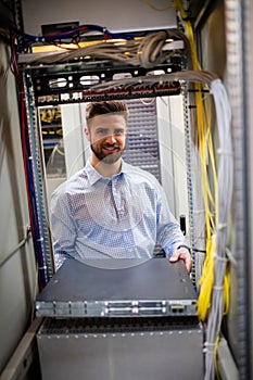 Technician removing server from rack mounted server