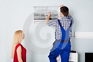 Technician Repairing Air Conditioner At Home